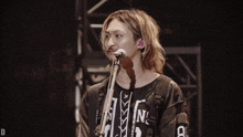 a man singing into a microphone wearing a shirt that says n on it