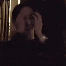 a couple of people are kissing in a dark room .