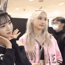 a girl wearing a pink jacket that says re