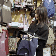 a woman holding a new york shirt in a store