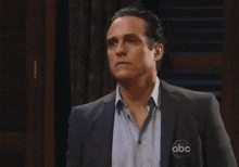 a man in a suit has a abc logo on his chest