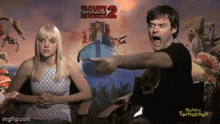 a man and a woman are sitting in front of a cloudy 2 poster