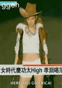 a woman in a cowboy hat is standing in front of a sign that says `` here you go erica ! ''