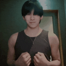 a man in a black tank top is standing in front of a door .