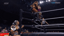 a woman in a wrestling ring with the aew dynamite logo on the screen