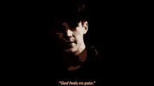 a close up of a man 's face with the words `` god feels no pain '' .
