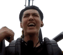 a man is riding a roller coaster and making a face .