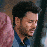 a close up of a man 's face with his eyes closed and a beard