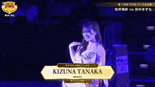 a woman named kizuna tanaka is smiling in a wrestling ring