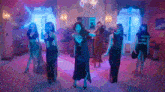 a group of women are dancing in a room