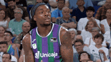 a basketball player wearing a purple and green uniform with the word unicaja on the front