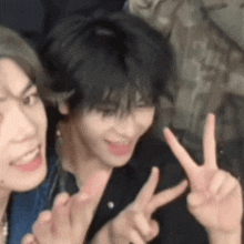 two people are giving the peace sign with their fingers