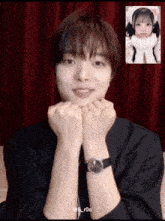 a man wearing a watch has a picture of a girl behind him