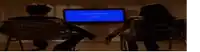 a man and a woman are sitting in chairs in front of a computer monitor with a blue screen that says error message