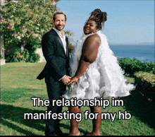 a man in a suit and a woman in a white dress holding hands with the caption the relationship im manifesting for my hb