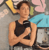 a young man is holding a microphone that says nettavision on it