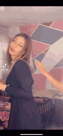 a woman in a black dress is dancing in a room .
