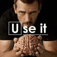 a man is holding a brain in his hands with the words `` use it '' written on it .