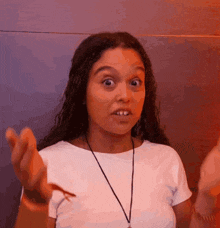 a woman with a necklace around her neck making a surprised face