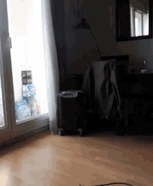 a room with a sliding glass door and a black suitcase on the floor