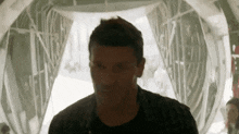 a man in a black shirt is standing in a tunnel looking at something .