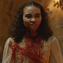 a woman with blood on her face is making a face