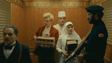 a group of people are standing in an elevator and one of them has a badge that says ' a.m. '
