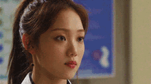 a close up of a woman 's face with a ponytail and red lipstick .