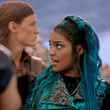 a woman with blue hair is standing next to a man with a headband