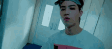 a young man wearing a bandana on his head is standing in a room .