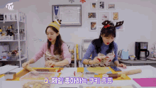 two women are sitting at a table with a sign that says toi