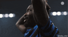 a man in a blue and black shirt with the number 1932 on the bottom
