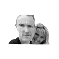 a man and a woman are posing for a picture together and smiling for the camera .