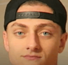 a close up of a man 's face wearing a baseball cap .
