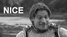 a man in armor is smiling in a black and white photo with the word nice in the background .