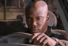 a man with a beard is driving a car and looking at his watch