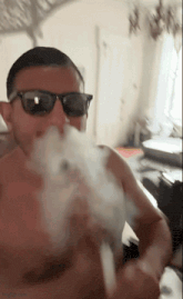 a man wearing sunglasses is smoking a cigarette
