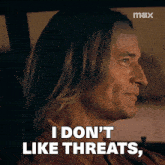 a man with long hair is sitting in a car and says i don 't like threats