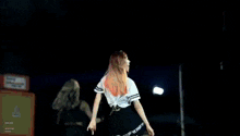 a woman with red hair is dancing on a stage with a shirt that says ' boys ' on it