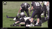 a football player with the number 15 on his back is being tackled