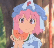 a girl with pink hair is holding a slice of watermelon in her hands .