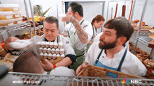 a group of chefs are working in a kitchen with a nbc logo in the background