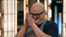 a man wearing glasses and an apron that says masterchef argentina on it