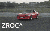 a red car is drifting on a track and the word zroca is on the bottom right