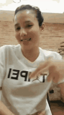 a woman wearing a white shirt with the word t on it