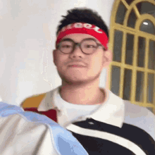 a young man wearing glasses and a red headband with the word cool on it