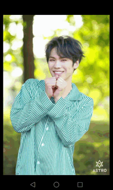 a man wearing a green and white striped shirt with astro written on it