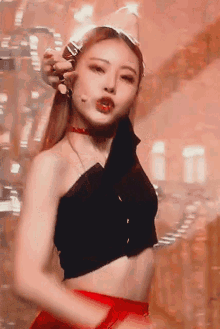 a woman in a black crop top and red skirt is dancing on a stage