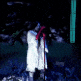 a woman in a white dress and red gloves sings into a microphone while a man plays a guitar in the background