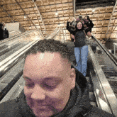 a man and a woman are riding an escalator